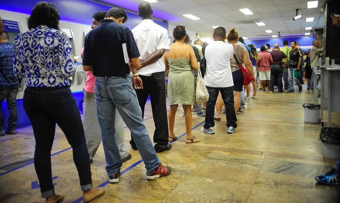 Clientes na fila do caixa eletrônico.