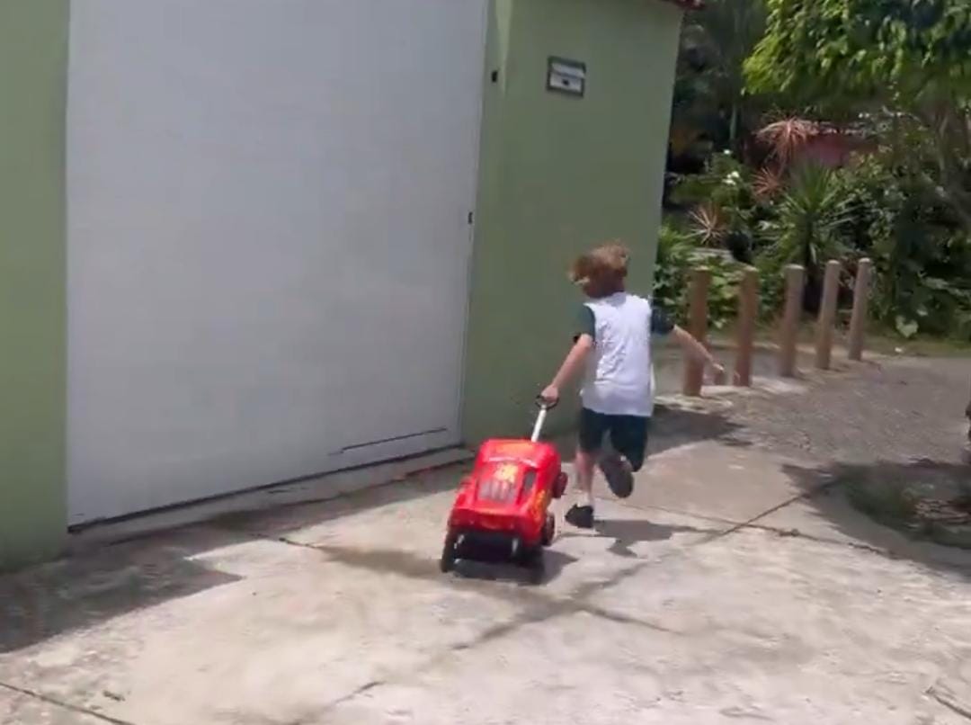 Garoto todo feliz indo mostrar sua mochila nova.