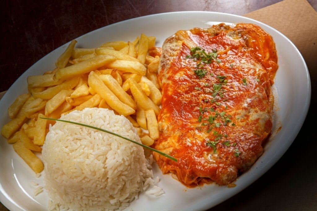 Bife à parmegiana com arroz e batata frita (Imagem: Norberto Marques | Shutterstock)