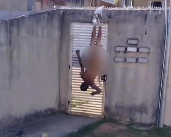 Ao pular o muro do condomínio onde a ex-namorada mora, a calça do homem se rasgou e ele ficou preso na cerca. 