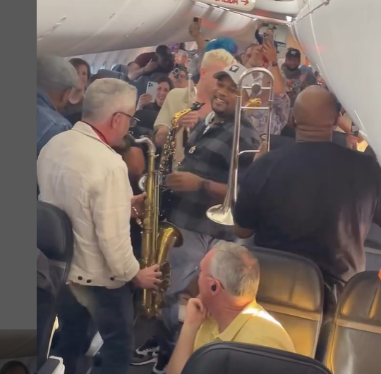 Imagem - Grupo de jazz transforma atraso de voo em momento descontraído dentro de avião; assista