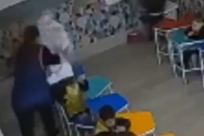 As câmeras de segurança da escola mostram o exato momento que a professora grita com o menino e, na sequência, joga uma pilha de livros contra o menino. 