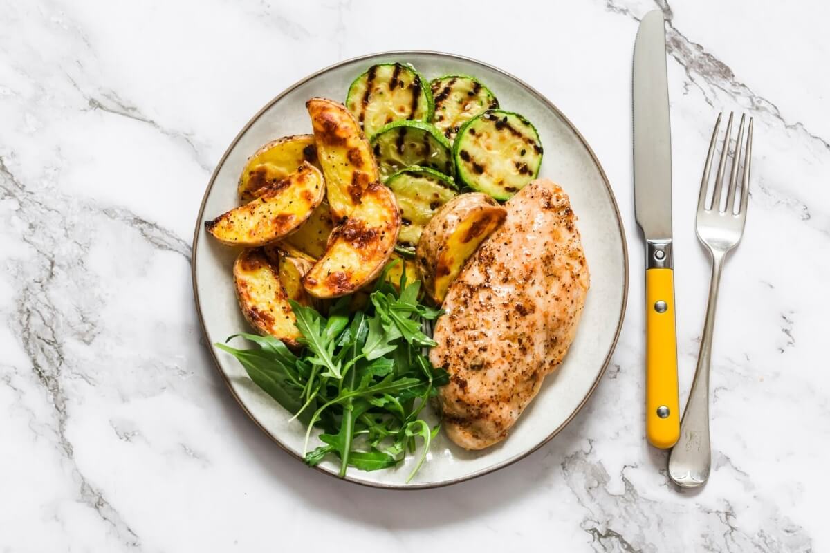 Frango assado com abobrinha e batata (Imagem: Kiian Oksana  | Shutterstock)