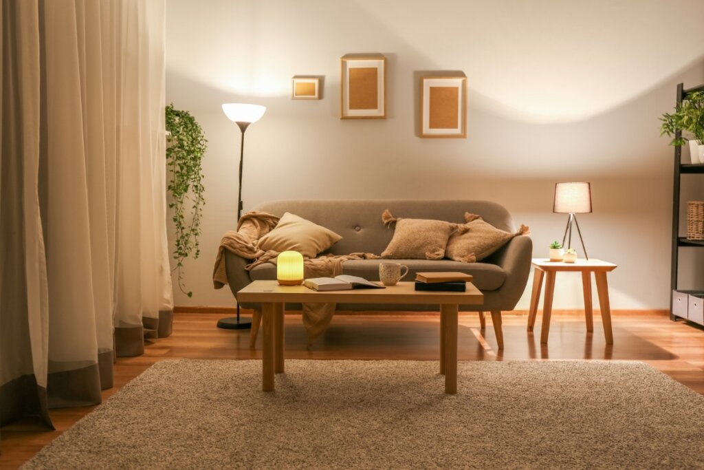 Luzes amareladas e indiretas ajudam a criar uma atmosfera acolhedora e relaxante na sala de estar (Imagem: Pixel-Shot | Shutterstock)