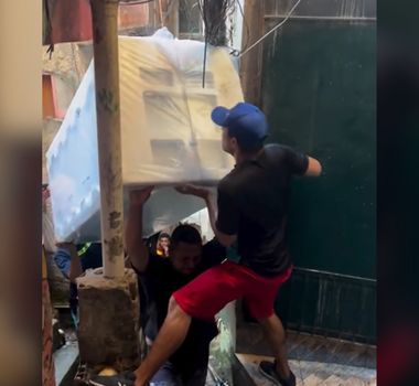 Imagem - Homens levando geladeira por vielas estreitas de favela viralizam