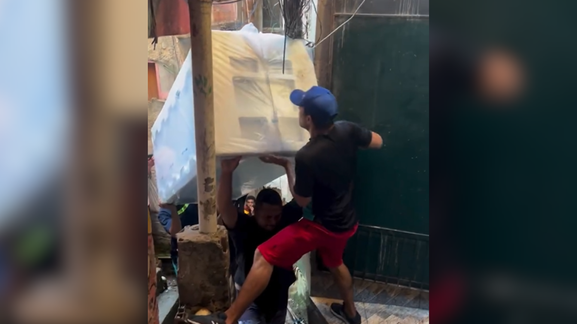 Imagem - Homens levando geladeira por vielas estreitas de favela viralizam