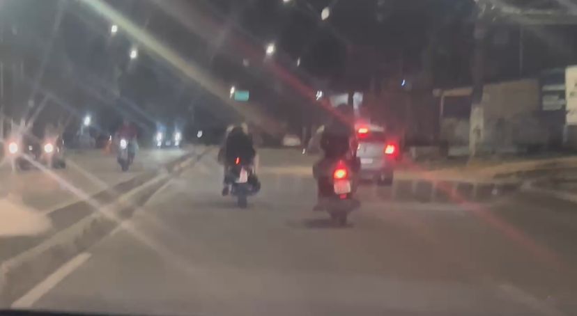 Nas imagens, uma das passageiras aparece cobrindo a identificação, enquanto a outra moto circula com a placa visivelmente adulterada