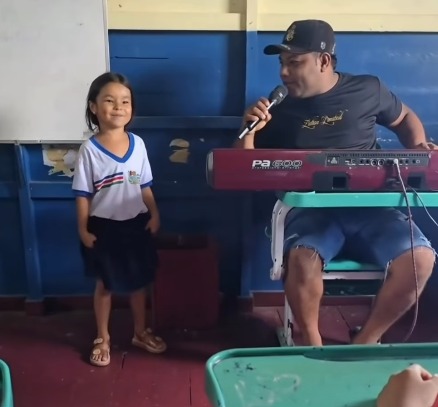 (A espontaneidade e a empolgação do momento chamaram atenção do público, principalmente pela forma carinhosa com que a aluna se entrega à homenagem.)