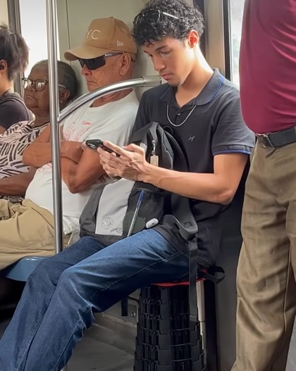 (Durante o trajeto de volta para casa, ele decidiu usar um pequeno banquinho portátil para viajar sentado.)