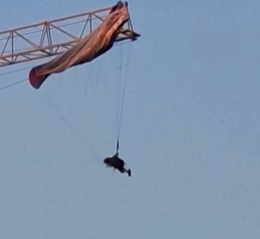Imagem - Parapentista fica preso em guindaste durante voo e é resgatado por bombeiros na China