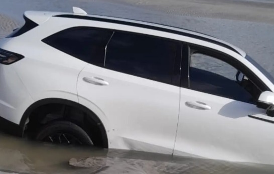 (Imagens registradas por banhistas mostram o veículo cercado pela maré, que avançou durante a noite e acabou "engolindo" o automóvel.)