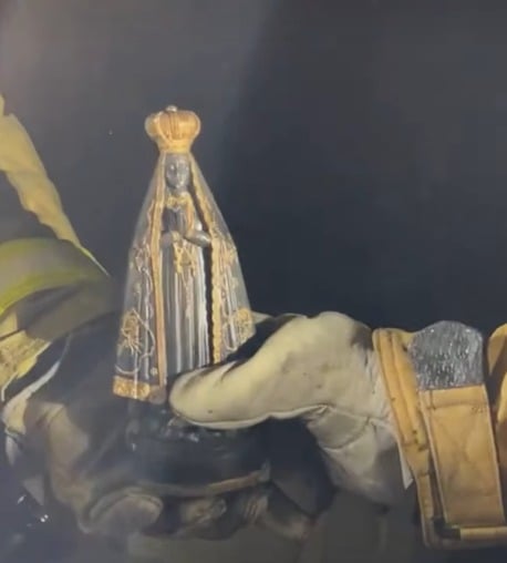 (A imagem de Nossa Senhora Aparecida foi encontrada totalmente intacta em meio aos destroços e à destruição causada pelo fogo.)