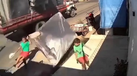 (A vítima foi identificada como Rosana Lima de Souza, de 55 anos. Ela caminhava pela calçada ao lado do neto quando o móvel se desprendeu do veículo em movimento.)