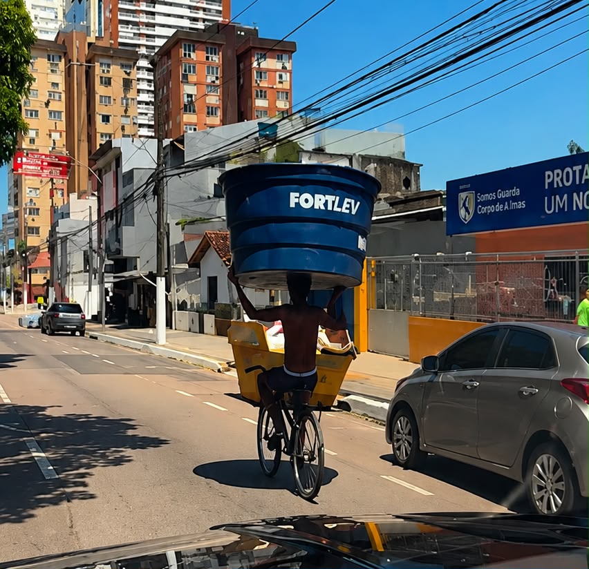 Homem levando caixa d'água na cabeça -