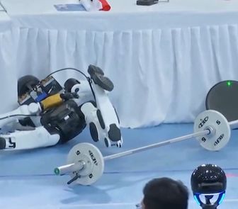 Imagem - Robô cai sobre mesa de juízes durante competição de levantamento de peso na China