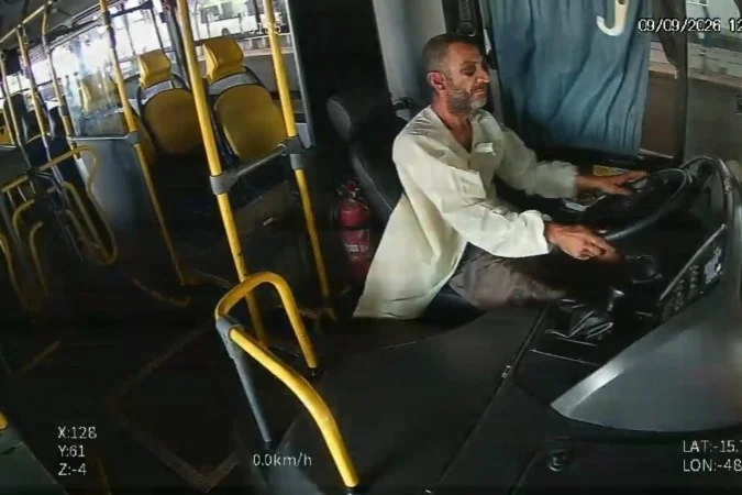 (Imagens do circuito interno do coletivo registraram o momento em que o suspeito entra no veículo carregando uma marmita. Pouco depois, ele assume a direção e deixa o local.)