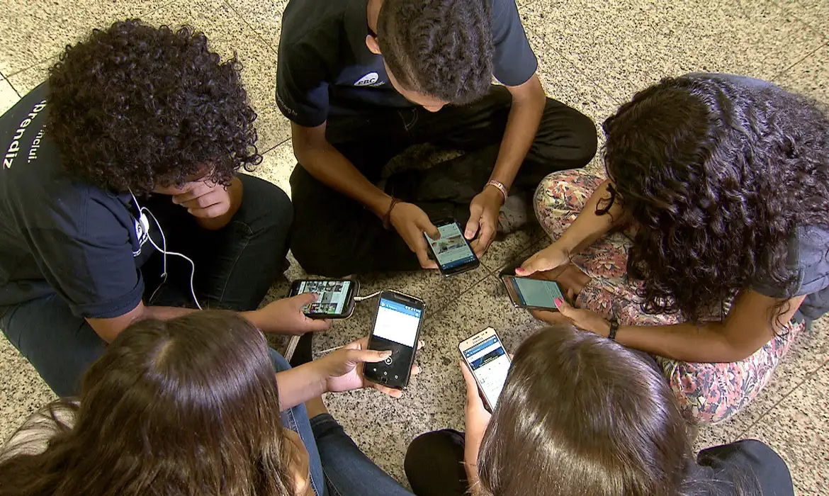 Imagem ilustrativa de crianças com celulares.