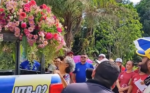 (Mesmo com dificuldades para caminhar, uma idosa fez questão de prestar sua homenagem à Santa.)